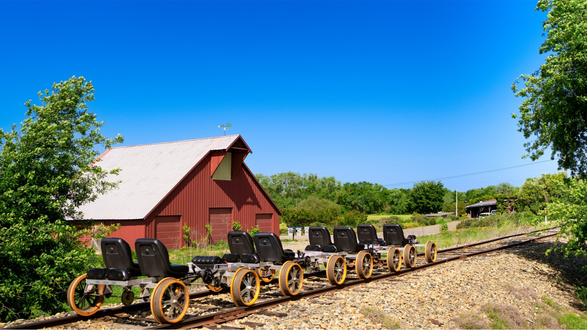 rail bikes with a barn house at the back and trees surrounding it